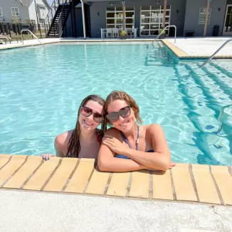 two young women relaxing in a resort style pool